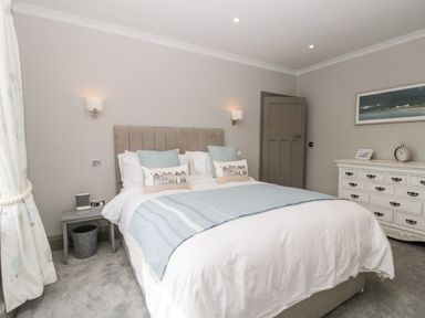 A bedroom with a bed a bedside table a dresser and framed artwork at 41 Chatsworth Gardens in Scarborough