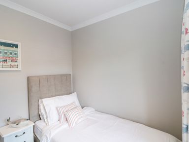 A bedroom with a single bed striped pillows and a nightstand with a whale decoration at 41 Chatsworth Gardens in Scarborough