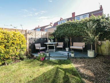 An outdoor patio area with chairs table plants and grass at 41 Chatsworth Gardens in Scarborough
