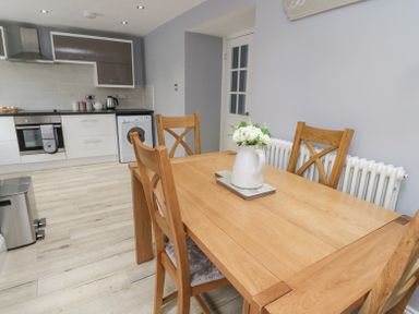 A kitchen and dining area with a wooden table and chairs and appliances at 4 Tyne View in Wark