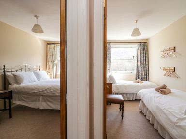 Two bedrooms separated by a wall each with beds and windows at Fellside View in Chapel Stile