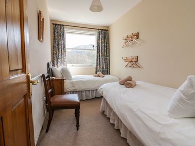 A bedroom with two single beds and a wooden chair by the window at Fellside View in Chapel Stile