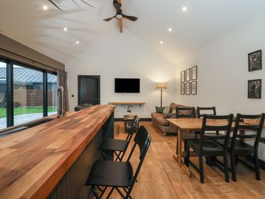 An open living and dining area with a wooden countertop and black chairs at Skylark in Bishop Wilton