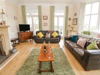 A living room with two leather sofas a wooden coffee table and a television on a wooden cabinet at Heatherbrae in Middleton-In-Teesdale