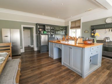 A kitchen with a large island counter and wooden floor at Heatherbrae in Middleton-In-Teesdale