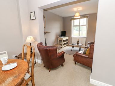 A living room with leather armchairs a coffee table and a TV at Heatherbrae in Middleton-In-Teesdale