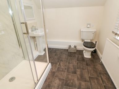 A bathroom with a shower enclosure a pedestal sink a toilet and a window with blinds at Heatherbrae in Middleton-In-Teesdale