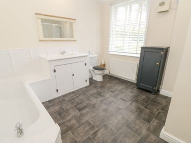 A bathroom with a bathtub sink toilet window and cabinet at Heatherbrae in Middleton-In-Teesdale