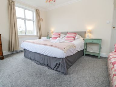 A bedroom with a double bed bedside tables and a window at Heatherbrae in Middleton-In-Teesdale