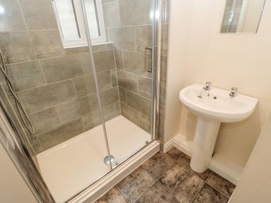 A bathroom with a glass shower enclosure and a white pedestal sink at Heatherbrae in Middleton-In-Teesdale