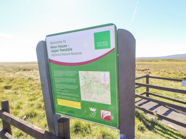 An outdoor information sign for Moor House Upper Teesdale National Nature Reserve in a grassy field at Heatherbrae in Middleton-In-Teesdale