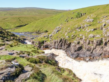 A river flowing through rocky hills with grassy slopes at Heatherbrae in Middleton-In-Teesdale