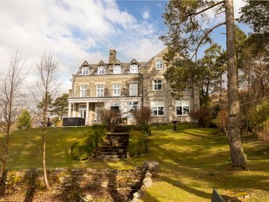 A stone house with multiple windows and a garden with stairs and trees at Heatherbrae in Middleton-In-Teesdale