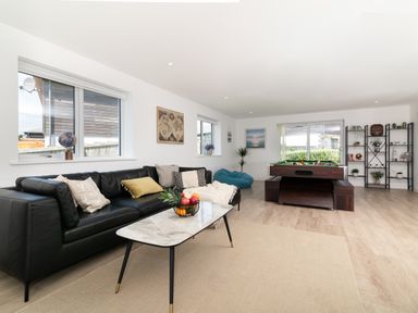 A living room with a pool table and seating area at Sandy Cove in Praa Sands