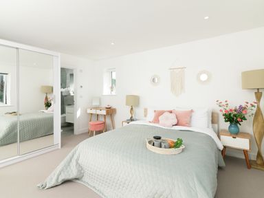 A bedroom with a bed and side table at Sandy Cove in Praa Sands
