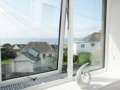 A view of the ocean and houses from a window at Sandy Cove in Praa Sands