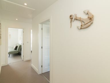 A hallway with an anchor decoration and a sofa at Sandy Cove in Praa Sands