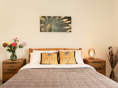 A bedroom with a bed and nightstands at Sandy Cove in Praa Sands