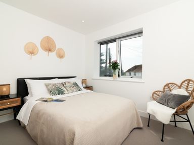 A bedroom with a bed and decorative wall pieces at Sandy Cove in Praa Sands
