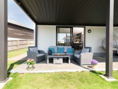 An outdoor seating area with a sofa and coffee table at Sandy Cove in Praa Sands
