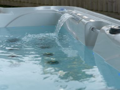 A hot tub with water and jets at Sandy Cove in Praa Sands