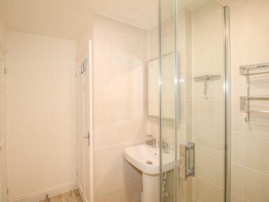 A bathroom with a sink pedestal mirror and glass shower enclosure at Brewers Retreat in Weymouth