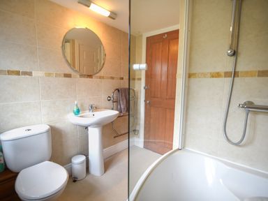 A bathroom with a toilet sink mirror bathtub and shower at Barley Cottage in Weycroft near Axminster