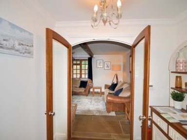 A living room with two sofas a floor lamp framed pictures and a rug at Barley Cottage in Weycroft near Axminster