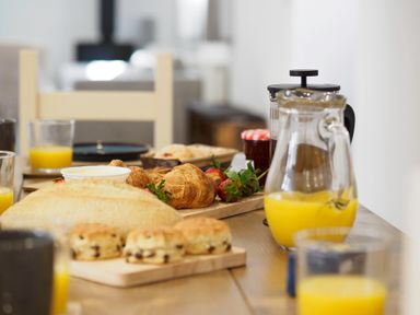 A dining table with croissants scones strawberries orange juice and a French press at Trelawney in Mawnan Smith Near Falmouth