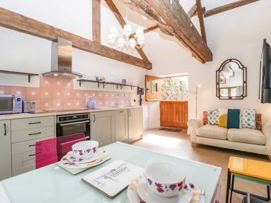 A kitchen and living area with wooden beams and a small sofa at The Forge in Taunton