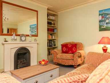 A living room with armchairs a coffee table and a fireplace at Drakes Retreat in Plymouth