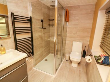 A bathroom with a shower enclosure a toilet a sink and a towel rack at Drake's Retreat in Plymouth
