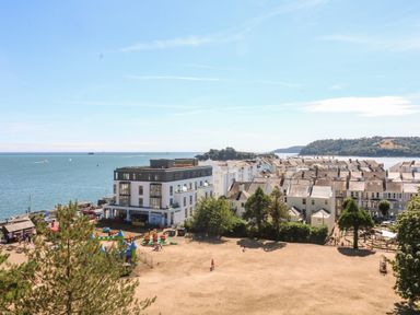 A seaside town with a playground and residential buildings near the water at Drake's Retreat in Plymouth