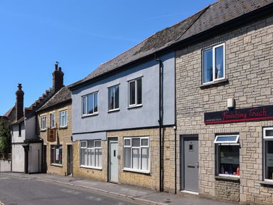 A street view of buildings including a hairdressing salon and a restaurant in Ayla Lyme Regis