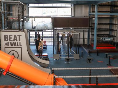 An indoor obstacle course area with climbing structures slides and people exercising at 3 Trem Y Dolydd in Dolgarrog near Llanrwst