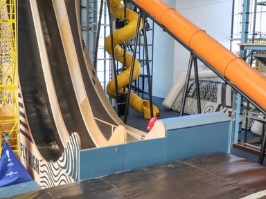 An indoor play area with large slides and a yellow spiral tube slide at 3 Trem Y Dolydd in Dolgarrog near Llanrwst