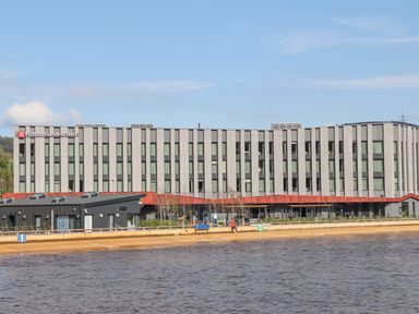 A multi-story hotel building behind a body of water at 3 Trem Y Dolydd in Dolgarrog near Llanrwst