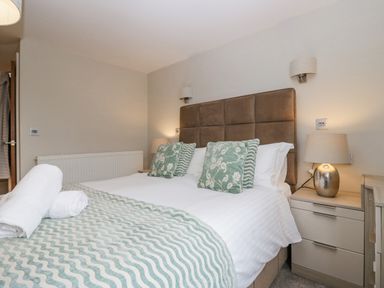 A bedroom with a double bed two bedside tables and lamps at Holme Fell Coniston