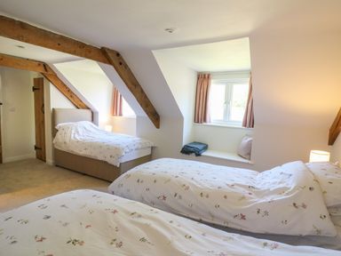 A bedroom with three single beds and wooden beams at Cattle Tree Cottage Llangoedmor near Cardigan