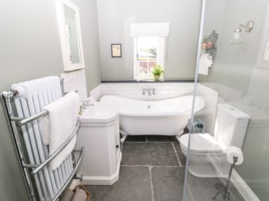 A bathroom with a bathtub sink toilet and a towel rail at Catamouse in Milford Haven