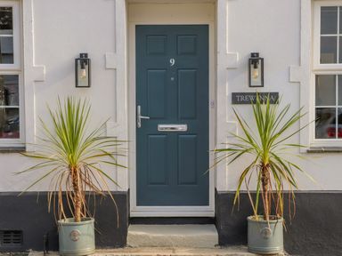The front door numbered 9 with two potted plants and wall lights on either side at Trewenna Roseland Tregony