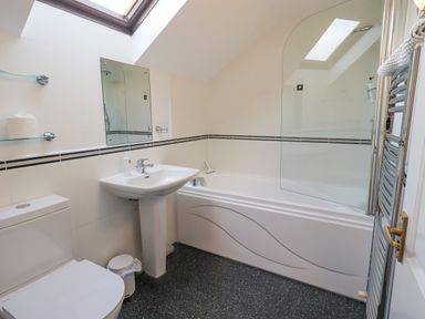 A bathroom with a toilet sink bathtub and skylight window at Beechside in Ambleside