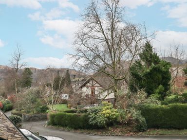 A residential area with houses trees hedges and a road at Beechside in Ambleside