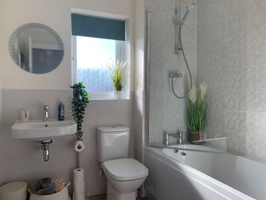 A bathroom with a sink toilet bathtub shower and plants at 2 Boathouse Terrace Mawgan Porth