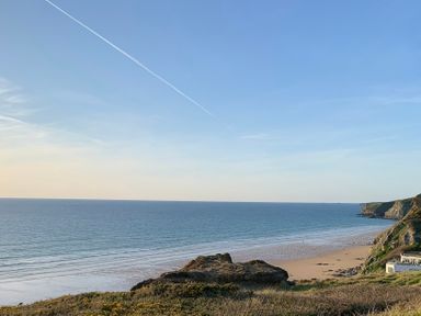A coastline view with cliffs a beach and ocean at 2 Boathouse Terrace in Mawgan Porth
