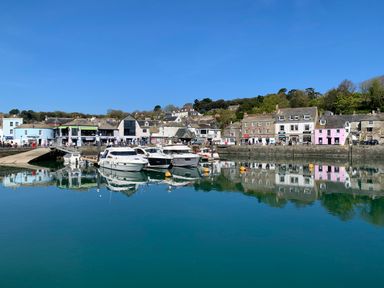 A harbor with boats docked and buildings along the waterfront at 2 Boathouse Terrace in Mawgan Porth