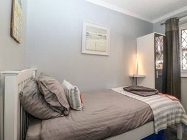 A bedroom with a bed and wardrobe at Ty Glan Morfa in Morfa Bychan