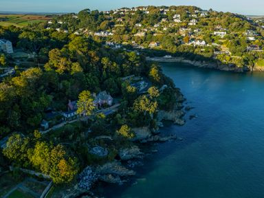 A coastal area with houses on a wooded hillside next to a body of water at 14 St Elmo Court in Salcombe