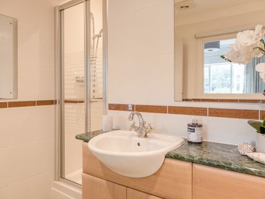 A bathroom with a sink countertop and a shower cubicle at 14 St Elmo Court in Salcombe