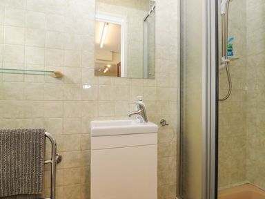 A bathroom with a washbasin cabinet mirror shower with sliding door and towel rail